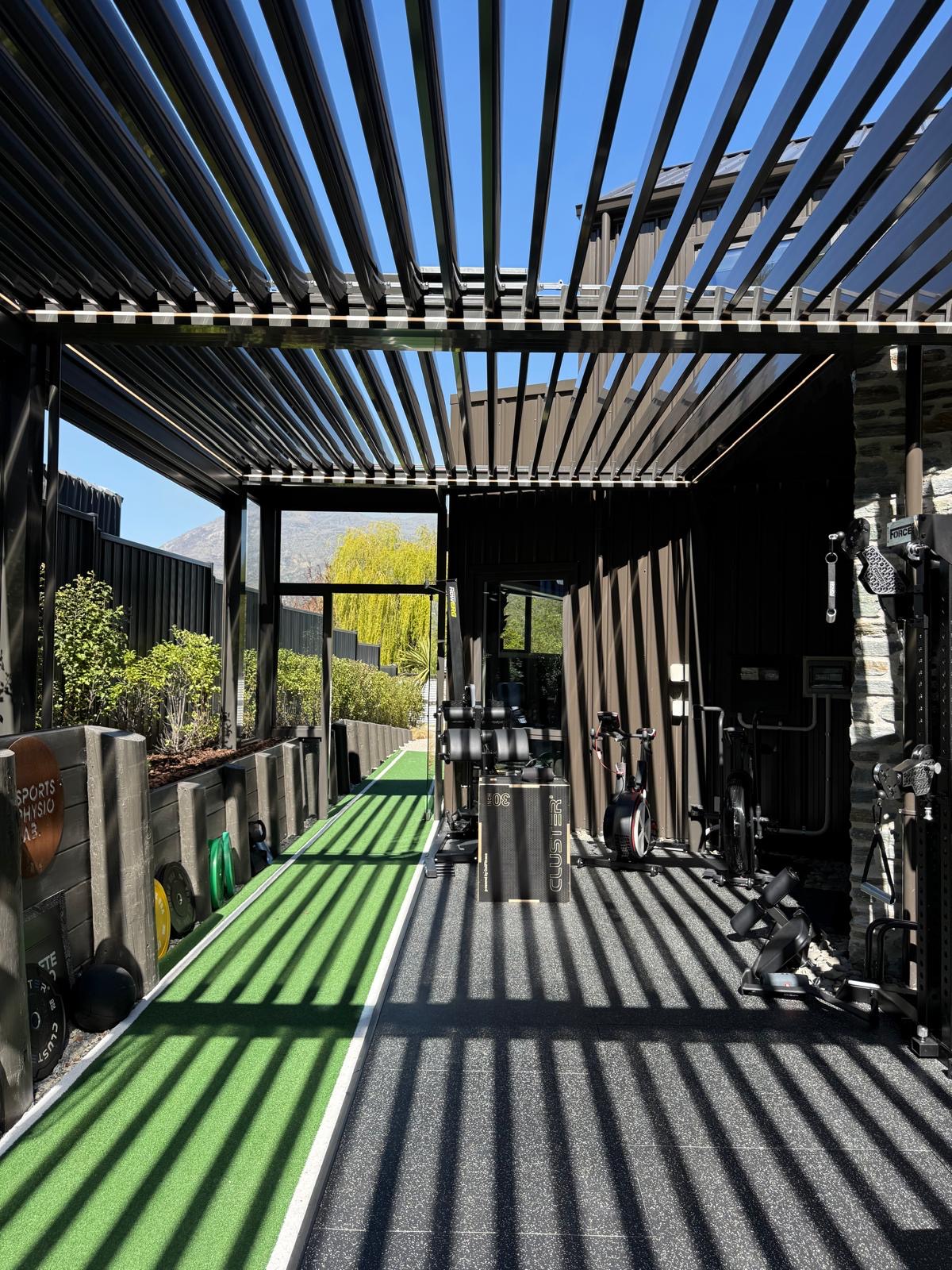 Open louvre roof with LED lighting over an outdoor home gym in Queenstown
