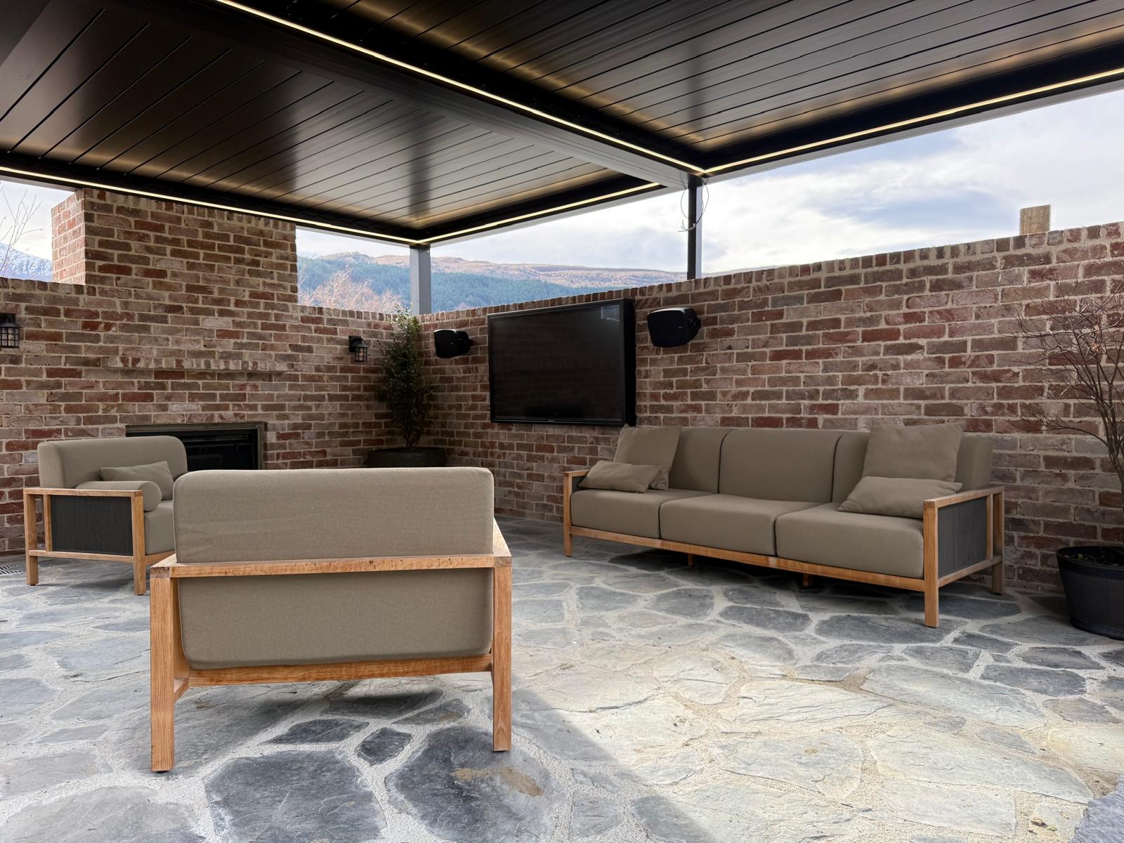 Louvre roof with LED lighting over an outdoor lounge with brick walls in Queenstown