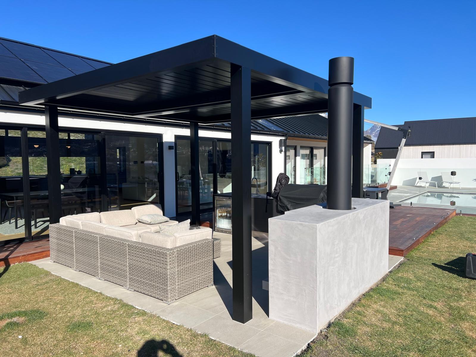 Freestanding black louvre roof beside a home and pool in Queenstown